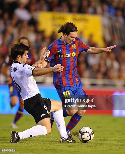 Lionel Messi of Barcelona is tackled by David Albelda of Valencia during the La Liga Match between Valencia and Barcelona at Estadio Mestalla on...