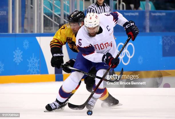 Marcus Kink of Germany competes for the puck against Jonas Holos of Norway in the second period during the Men's Ice Hockey Preliminary Round Group B...