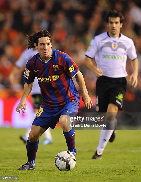 Lionel Messi of Barcelona is persued by David Albelda of Valencia during the La Liga Match between Valencia and Barcelona at Estadio Mestalla on...