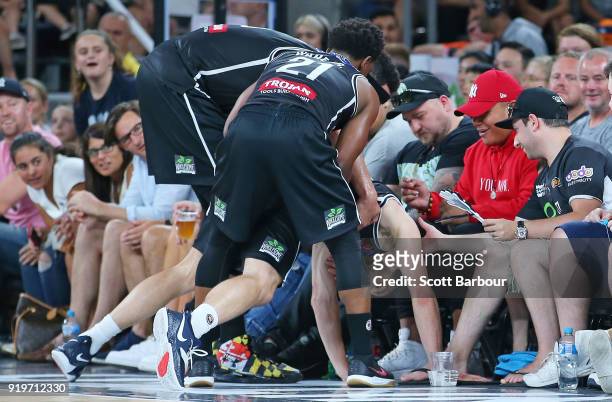 Chris Goulding of Melbourne United is helped up by his teammates after sliding into the crowd during the round 19 NBL match between Melbourne United...