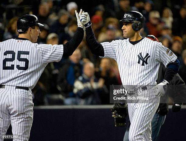 Derek Jeter of the New York Yankees is congratulated by Mark Teixeira after Jeter hit a home run in the bottom of the third inning during Game Two of...