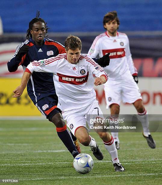 Logan Pause of the Chicago Fire drives past Shalrie Joseph of the New England Revolution during MLS match October 17 at Gillette Stadium in...