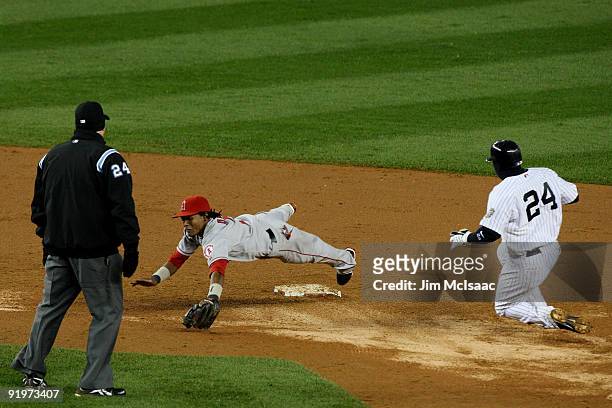 Robinson Cano of the New York Yankees runs to second base on a throwing error by Maicer Izturis of the Los Angeles Angels of Anaheim which Erick...