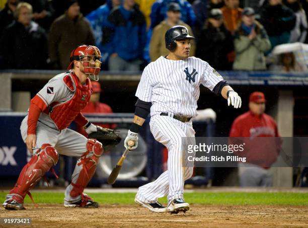 Melky Cabrera of the New York Yankees hits a single to score the game-winning run in the 13th inning of Game Two of the ALCS against the Los Angeles...