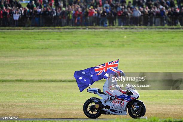 Casey Stoner of Australia and Ducati Marlboro Team celebrates with the flag of Australia the victory in MotoGP race at the end of MotoGP race of the...