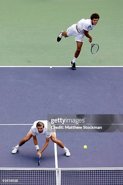 Jo-Wilfried Tsonga of France serves to Mariusz Fyrstenberg and Marcin Matkowski of Poland while playing with Julien Benneteau of France during the...