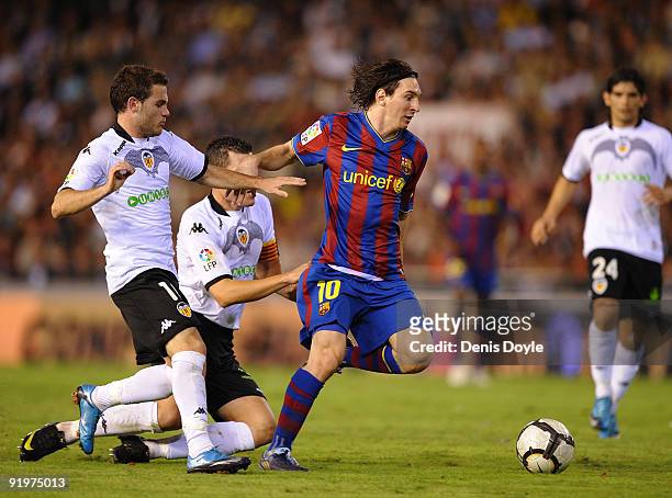 Lionel Messi of Barcelona beats Ruben Baraja of Valencia during the La Liga Match between Valencia and Barcelona at Estadio Mestalla on October 17,...