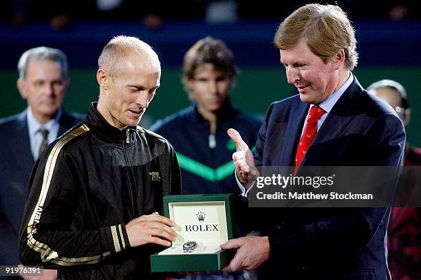 Nikolay Davydenko of Russia is presented with a Rolex by Rolex CEO Bruno Meier after defeating Rafael Nadal of Spain during the final on day eight of...