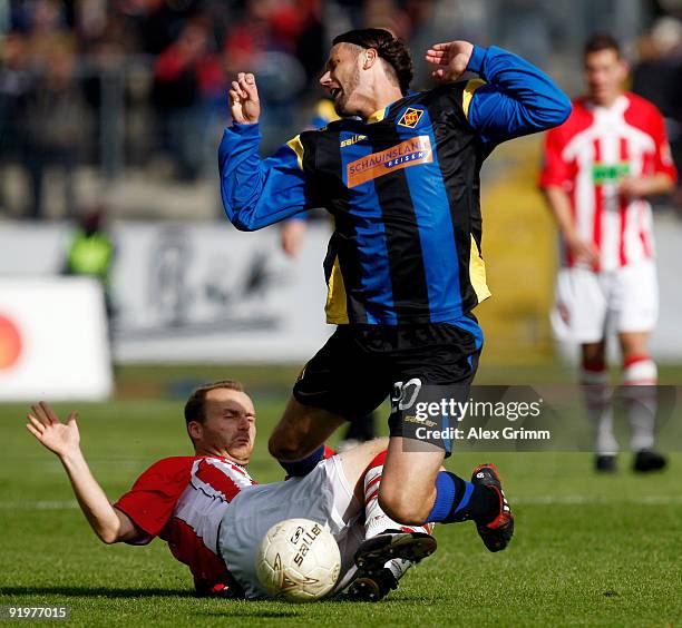 Melinho of Koblenz is tackled by Lars Toborg of Ahlen during the Second Bundesliga match between TuS Koblenz and Rot-Weiss Ahlen at the Oberwerth...