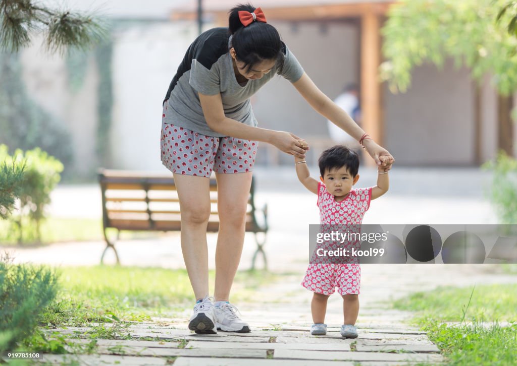 Baby Getting Help Mother Help The Baby Take The First Step In Life High-Res Stock Photo ...