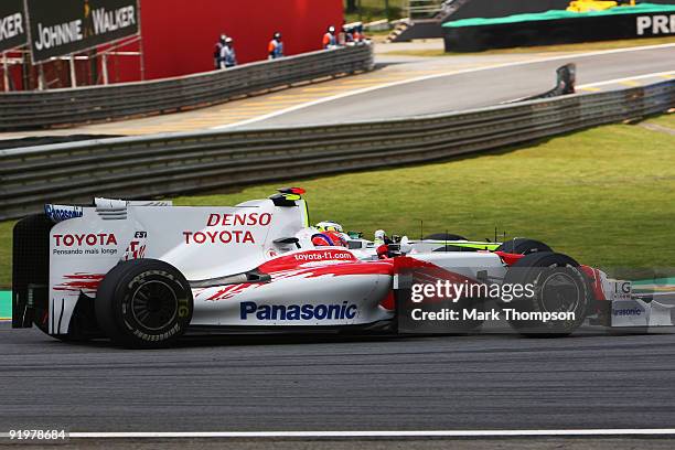 Kamui Kobayashi of Japan and Toyota and Jenson Button of Great Britain and Brawn GP race into turn one during the Brazilian Formula One Grand Prix at...