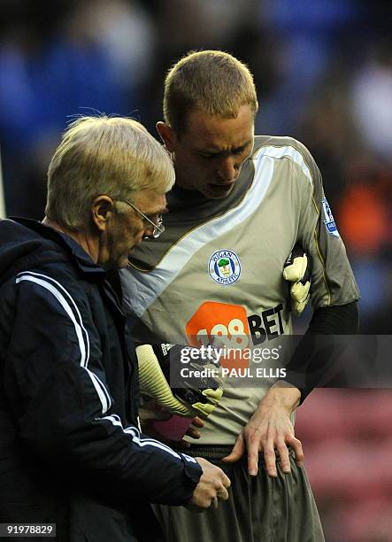 Wigan Athletic's English goalkeeper Chris Kirkland receives attention to his finger during the English Premier League football match between Wigan...