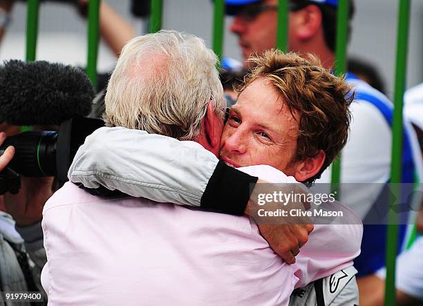 Jenson Button of Great Britain and Brawn GP is congratulated by his father John Button after clinching the F1 World Drivers Championship during the...