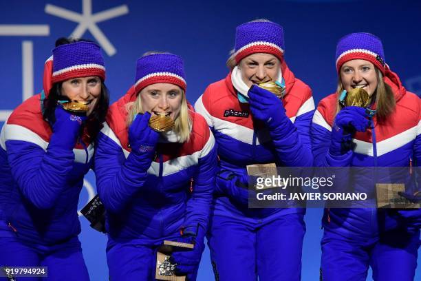 Norway's gold medallists Ingvild Flugstad Oestberg, Astrid Uhrenholdt Jacobsen, Ragnhild Haga and Marit Bjeorgen bite their medals on the podium...