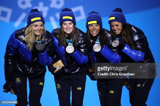 Silver medalists Anna Haag, Charlotte Kalla, Ebba Andersson and Stina Nilsson of Sweden celebrate during the medal ceremony for the Cross-Country...