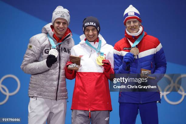 Silver medalist Andreas Wellinger of Germany, gold medalist Kamil Stoch of Poland and bronze medalist Robert Johansson of Norway celebrate during the...