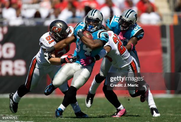 Running back DeAngelo Williams of the Carolina Panthers is tackled by defenders Barrett Ruud and Ronde Barber of the Tampa Bay Buccaneers during the...