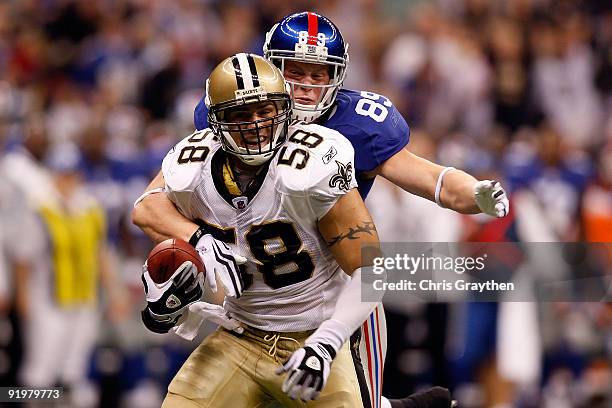 Scott Shanle of the New Orleans Saints is tackled by Kevin Boss of the New York Giants after recovering a fumble at the Louisiana Superdome on...