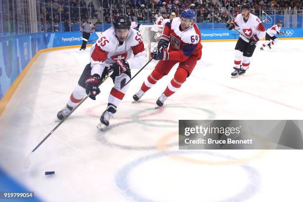 Romain Loeffel of Switzerland skates with the puck against Jiri Sekac of the Czech Republic during the Men's Ice Hockey Preliminary Round Group A...