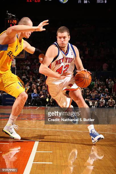David Lee of the New York Knicks drives against Maciej Lampe the Maccabi Electra Tel Aviv on October 18, 2009 at Madison Square Garden in New York...