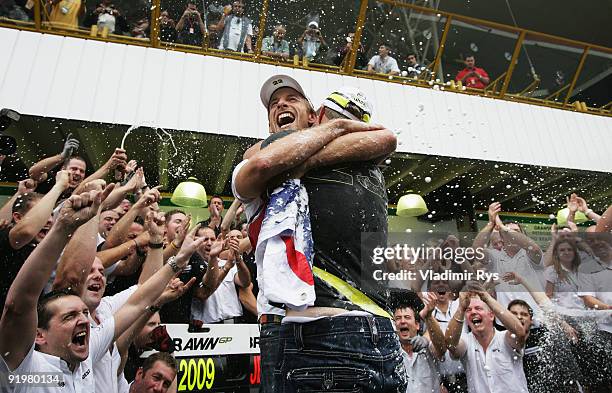 Jenson Button of Great Britain and Brawn GP is congratulated by team mate Rubens Barrichello of Brazil and Brawn GP as he celebrates in the pitlane...
