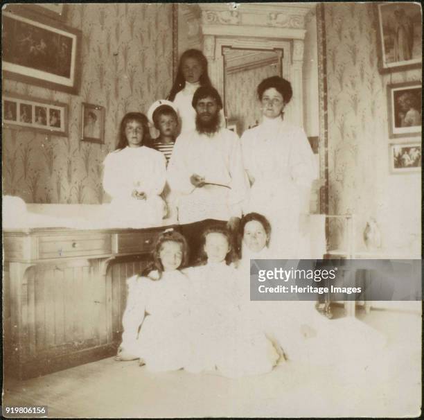 Grigory Rasputin with Empress Alexandra Fyodorovna, her five children and seated right governess Maria Vishnyakova, 1910. Found in the collection of...