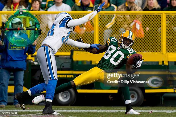 Donald Driver of the Green Bay Packers hauls in a pass against Demarcus Faggins the Detroit Lions at Lambeau Field on October 18, 2009 in Green Bay,...