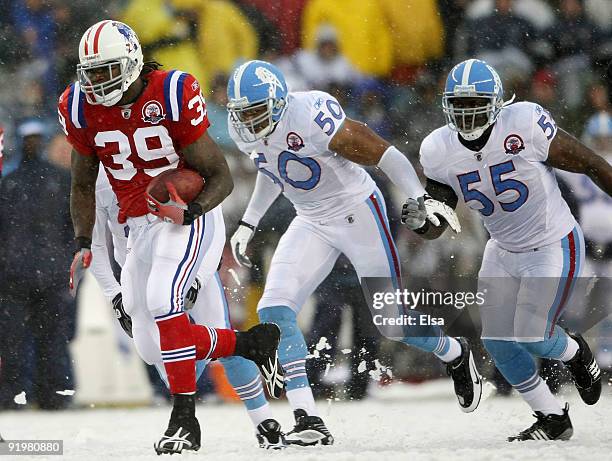 Laurence Maroney of the New England Patriots carries the ball in for a touchdown as David Thornton and Stephen Tulloch of the Tennessee Titans chase...