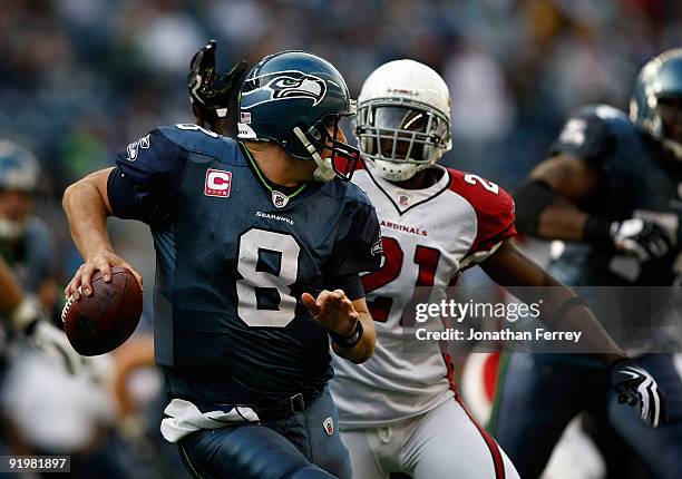 Quarterback Matt Hasselbeck of the Seattle Seahawks is pressured by Antrel Rolle of the Arizona Cardinals at Qwest Field on October 18, 2009 in...