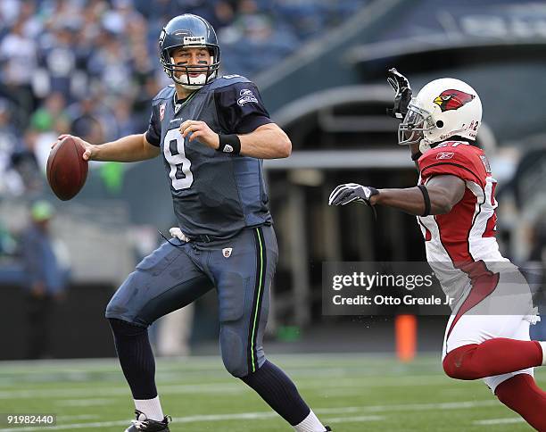 Quarterback Matt Hasselbeck of the Seattle Seahawks scrambles against Antrel Rolle of the Arizona Cardinals on October 18, 2009 at Qwest Field in...