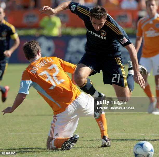 Bobby Boswell of the Houston Dynamo trips Alan Gordon of the Los Angeles Galaxy at Robertson Stadium on October 18, 2009 in Houston, Texas.