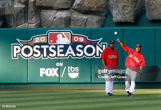 Howie Kendrick and Chone Figgins of the Los Angeles Angels of Anaheim shag balls in the outfield during an off-day workout part of the ALCS during...