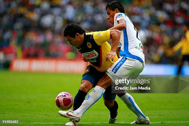 Salvador Cabanas of America vies for the ball with Pablo Aja of Puebla during their match in the 2009 Opening tournament, the closing stage of the...