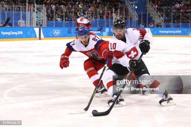 Andres Ambuhl of Switzerland skates with the puck against Jakub Nakladal of the Czech Republic during the Men's Ice Hockey Preliminary Round Group A...