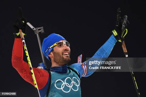 France's Martin Fourcade celebrates winning gold at the finish line in the men's 15km mass start biathlon event during the Pyeongchang 2018 Winter...