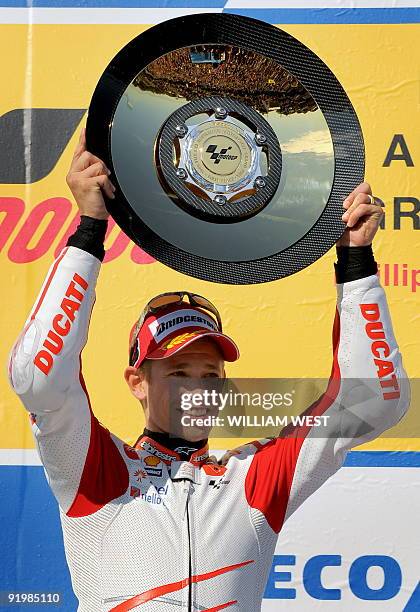 Australian rider Casey Stoner holds the trophy aloft after winning the Australian MotoGP on his Ducati at Phillip Island, some 100kms south-east of...