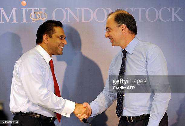 London Stock Exchange Chairman Xavier Rolet shakes hands with Sri Lanka's MillenniumIT's Chief Executive, Tony Weerasinghe in Colombo on October 19,...