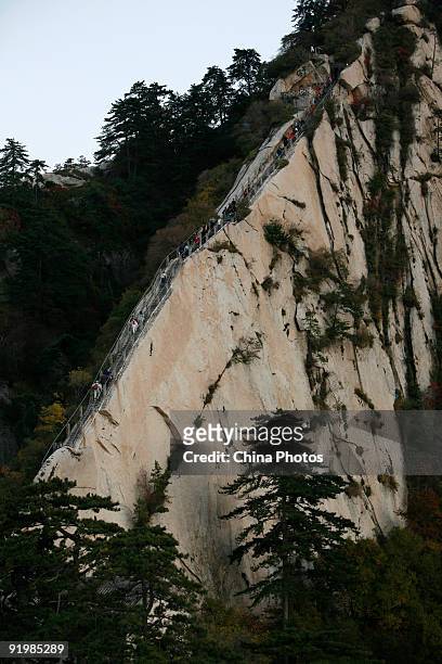 Tourists climb along the Canglong Ridge on the Huashan Mountain on October 18, 2009 in Huayin, Shaanxi Province, China. Huashan, located at an...