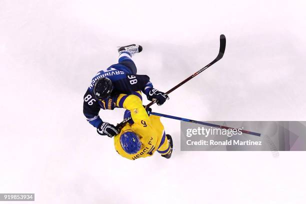 Patrik Hersley of Sweden throws a punch against Veli-Matti Savinainen of Finland in the first period during the Men's Ice Hockey Preliminary Round...