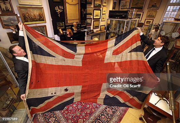 Employees for Charles Miller auctioneers hold a giant union flag, which was flown from HMS Spartiate at the battle of Trafalgar on October 21 in...