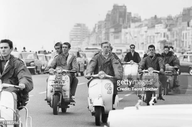 Mods ride their scooters along the seafront at Hastings, East Sussex, 4th August 1964.