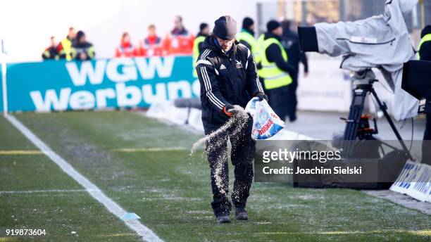 The groundskeeper spreads salt on the lawn before the 3. Liga match between Sportfreunde Lotte and VfL Osnabrueck at Frimo Stadion on February 18,...
