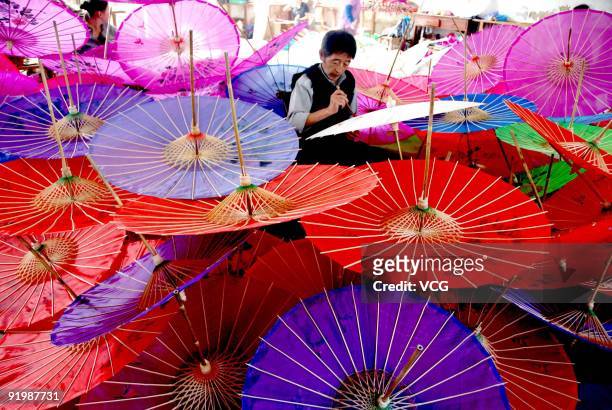 Man painting on the umbrella, made of oiled paper and bamboo frame, on October 18, 2009 in Wuyuan Country, Jiangxi Province of China. Paper umbrella...