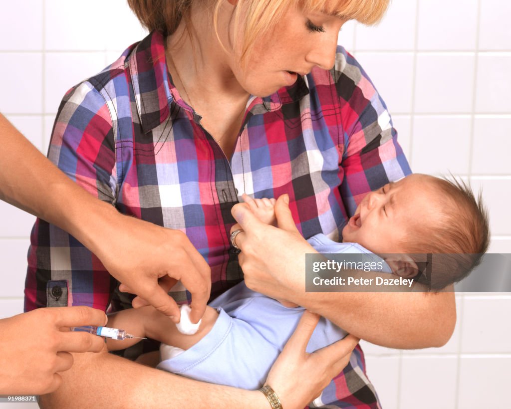 Teenage mother holding eight week old baby.