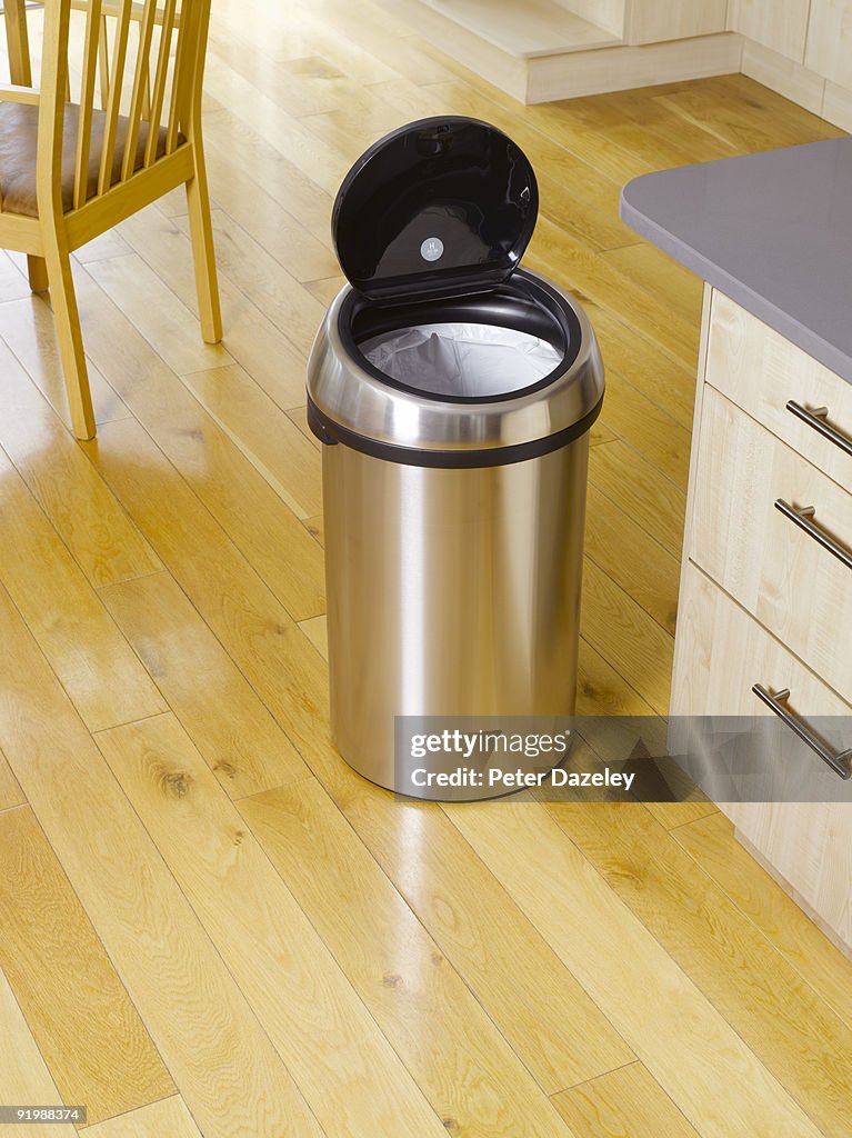 Garbage bin in kitchen setting.