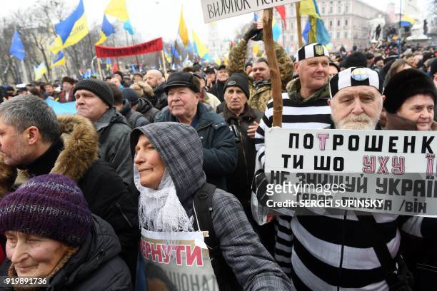 An activist holds a placard reading "Poroshenko do not destroy Ukraine" during a mass march and rally calling for the impeachment of Ukrainian...