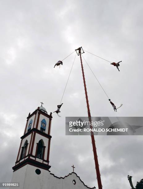 Mexican Totonaca natives perform the ritual dance of "Los Voladores" at the main square of Papantla, in the state of Veracruz, on October 17, 2009....