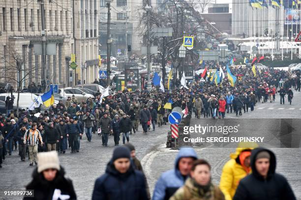 Activists carry flags and shout slogans during a mass march and rally calling for the impeachment of Ukrainian president Petro Poroshenko organized...