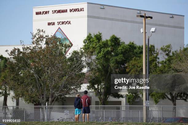 Charles Lambeth and Joey Wong alumni of the Marjory Stoneman Douglas High School look on at the school on February 18, 2018 in Parkland, Florida....