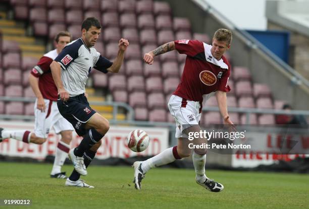 Richard Butcher of Lincoln City and Dean Beckwith of Northampton Town challenge for the loose ball during the Coca Cola League Two match between...